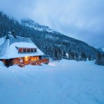 Chalet en bois illuminé au cœur de la montagne enneigée