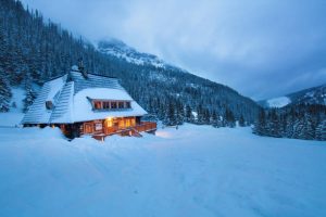 Chalet en bois illuminé au cœur de la montagne enneigée